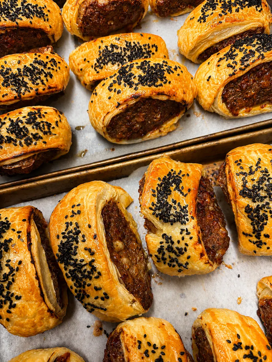 Freshly baked sesame-topped sausage rolls at Not typical